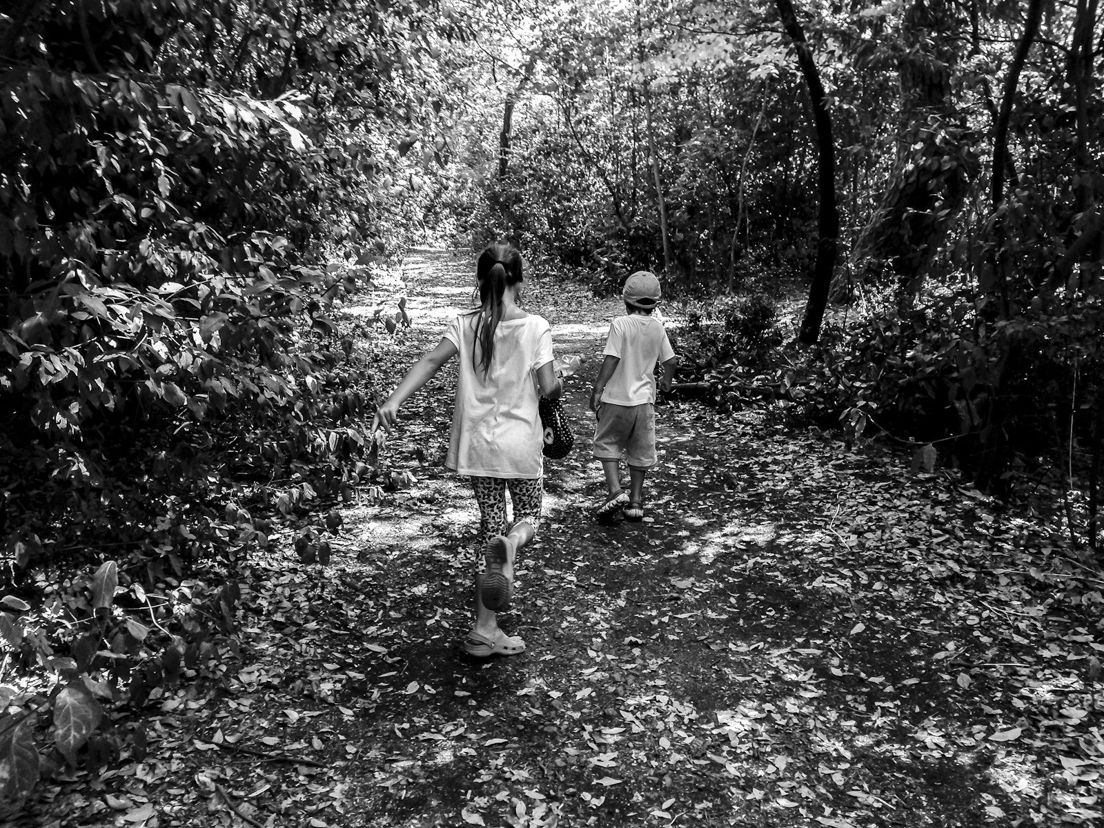 grayscale photo of boy and girl walking